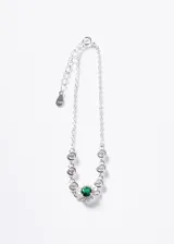 Pulsera de plata 925 con cadena forcé, adornada con zirconias blancas y una zirconia central de color verde rodeada de zirconias más pequeñas.