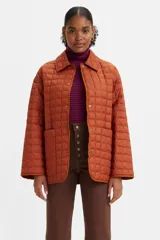 Campera acolchada color ladrillo con cuello camisero, cierre con botones a presión, bolsillos laterales y corte holgado.