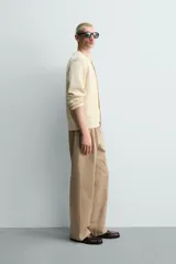 Cardigan de punto en hilatura de algodón y lino, con ajuste regular, cuello redondo, manga larga y acabados en rib. Presenta cierre frontal de botonadura con botones oscuros.
