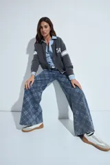 Jean de corte wide leg con estampado de cuadros en tonos azules. Presenta un diseño de tiro medio y silueta amplia, confeccionado en denim estructurado.