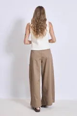 Chaleco de punto color crema con escote en V y cierre frontal con botones a tono.