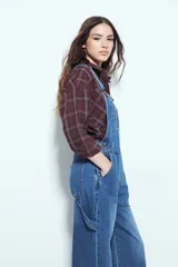 Enterito de denim negro con calce relajado y silueta amplia, inspirado en la estética workwear. Presenta tiradores regulables, pechera con bolsillo frontal y bolsillos laterales funcionales.