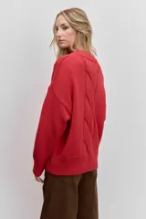 Sweater de punto en color beige, con cuello redondo acanalado, mangas largas con puños ajustados y diseño holgado.