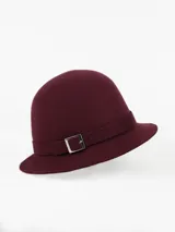 Sombrero tipo cloche de paño de lana impermeable color bordó, con cinta decorativa y hebilla metálica plateada.