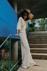 Pantalón palazzo de tiro medio en color marrón, confeccionado en tejido con textura. Cuenta con cintura elástica ajustable mediante cordones y diseño de pierna ancha.