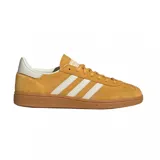 Championes adidas Handball Spezial de diseño retro, confeccionados en gamuza color mostaza con las icónicas tres tiras laterales en blanco. Presentan una suela de goma natural y detalles en blanco en el talón.