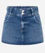 Minifalda de jean azul con cintura baja, cierre frontal con doble botón y bolsillos funcionales. Presenta un diseño estructurado con ruedo levemente redondeado.