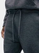 Pantalón tipo babucha de color azul oscuro, confeccionado con interior de felpa. Presenta cintura elástica con cordón de ajuste y puños acanalados en los tobillos.