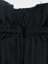 Top negro strapless con cuerpo fruncido tipo smock y bajo abullonado con acabado peplum.