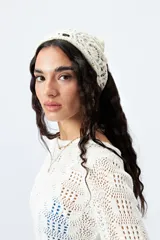 Pañuelo de tejido crochet color crema.