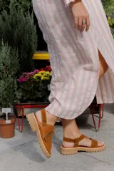 Sandalias de plataforma con suela track, confeccionadas en una combinación de cuero liso y cuero con textura croco. Presentan tiras anchas en el empeine y cierre con hebilla ajustable en el talón.