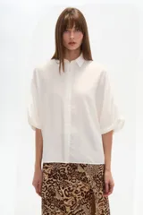 Camisa de viscosa color blanco, de corte holgado, con cuello camisero y cierre frontal de botones.
