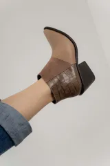 Bota corta de cuero color marrón con paneles de gamuza y cuero texturizado.