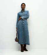 Pollera midi de corte evasé confeccionada en denim de algodón. Presenta cintura alta con pasantes, cierre frontal con botón y cremallera, bolsillos funcionales y costuras verticales decorativas que estructuran la prenda.