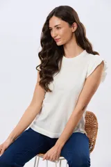 Remera de punto lisa color blanco, sin mangas, con cuello redondo y detalles de volados en los hombros.