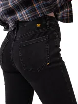 Jeans de corte ajustado y tiro medio, confeccionados en denim elástico color negro. Presentan cierre de cremallera, diseño clásico de cinco bolsillos, remaches metálicos con logo y parche identificatorio en la cintura trasera.