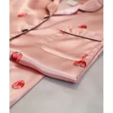 Pijama de dos piezas compuesto por una camisa de manga corta con botones frontales y un short, ambos con estampado animal print y detalles de vivo en contraste.