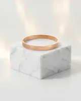 Esclava rígida de acero con baño de oro rosa y diseño de guarda griega grabada en toda su superficie.