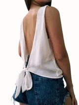 Blusa rosa sin mangas con espalda descubierta y lazo en la cintura.