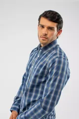 Camisa de manga larga con diseño de cuadros en tonos azules, blancos y negros. Presenta cuello clásico, cierre frontal con botones y logo bordado en el pecho. Corte semi slim.