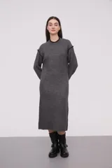 Vestido midi gris de tejido de punto, con cuello redondo y mangas largas. Presenta ribete negro en cuello, puños y hombros.