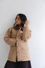 Campera estilo cargo color tostado con cuello de pana marrón, múltiples bolsillos delanteros y cierre frontal con botones a presión.