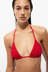 Top de bikini triangular rojo con textura estilo crochet, copas con relleno extraíble y tiras para atar en el cuello y la espalda.