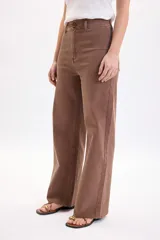 Pantalón jean ancho y elastizado en color marrón, de corte recto y tiro medio, con bolsillos y trabillas para cinto.