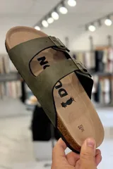 Sandalia marrón con diseño de dos tiras ajustables con hebillas metálicas y plantilla anatómica.