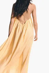 Vestido largo de corte holgado en tejido liviano, con diseño evasé, escote en V y breteles finos para atar en los hombros.