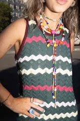 Vestido largo de punto con diseño de rayas en zigzag de colores verde oscuro, fucsia, rosa claro y amarillo, sin mangas y con escote redondo.