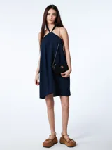 Vestido corto azul marino de tencel con corte evasé, cuello halter con lazo ajustable y espalda descubierta.