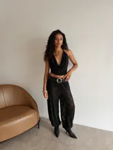 Pantalón tipo babucha de encaje negro con diseño floral, de corte holgado y puños ajustados en los tobillos.