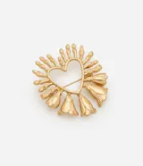 Broche de metal con baño de oro envejecido, diseñado con una silueta central de corazón calado rodeada por una estructura de pétalos en relieve. Cuenta con un sistema de cierre de seguridad en la parte posterior.