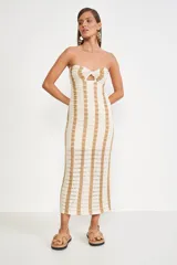 Vestido midi tejido a crochet, con diseño a rayas verticales color beige y crudo, corte ajustado, sin mangas y escote recto con abertura en forma de gota.
