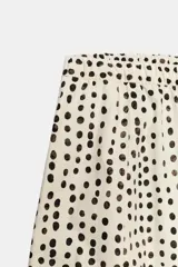 Pantalón estilo pijama de tiro medio, confeccionado 100% en algodón. Cuenta con cintura elástica, bolsillos laterales ocultos en la costura y diseño de corte barrel con estampado de lunares.