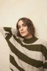 Polera de punto color beige con rayas horizontales anchas color verde oliva, cuello alto y mangas largas.