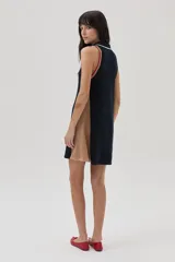 Vestido corto azul marino de tejido de punto, con cuello polo a rayas blancas, beige y rojas, y paneles laterales color beige.