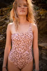 Malla enteriza asimétrica con estampado abstracto en tonos marrones y rosados.