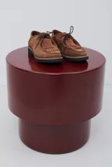 Zapato abotinado de gamuza color caramelo, con cordones, detalle de flecos en el empeine y suela de goma negra con costuras a la vista.