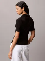 Chomba de Calvin Klein Jeans confeccionada en tejido de algodón con elastano, de corte regular y textura acanalada. Presenta cuello tipo polo con cartera de dos botones, mangas cortas e insignia de la marca en el pecho.