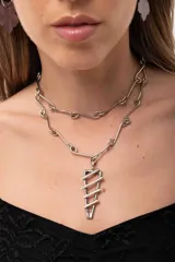 Collar de cadena artesanal con eslabones irregulares en forma de rulos y dije geométrico de diseño lineal. El diseño permite usarlo como collar largo o doble como gargantilla.