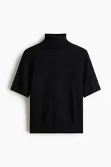 Top de punto fino negro, de manga corta y cuello alto acanalado. Presenta puños y bajo en punto acanalado.