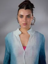 Saco largo de lana merino tejido con diseño jacquard de ramas, de líneas rectas y aberturas laterales, con efecto degradado en tonos azules y blancos, mangas largas con puños entallados y cierre frontal con pequeños botones.