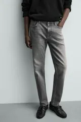 Pantalón de jean corte slim fit, color gris con efecto lavado. Presenta diseño de cinco bolsillos, cierre frontal con cremallera y botón, y tejido elástico.