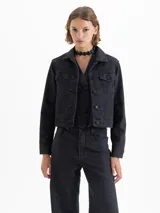 Campera de denim color negro, de silueta clásica y fit estándar, con leve elasticidad. Tiene cuello camisero, botones frontales y bolsillos con solapa en el pecho.