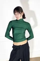 Polera verde esmeralda de lycra con cuello alto y mangas largas.