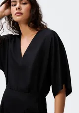 Blusa negra de manga corta, con escote pronunciado en V y corte holgado.