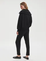 Pantalón negro de tejido DoubleSoft, corte ajustado con puños enrollados, pinzas delanteras y traseras, y bolsillos con forma.