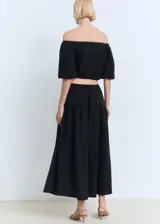 Falda larga evasé de tiro bajo y color negro, confeccionada en tejido 100% algodón, con cintura elástica y cordón ajustable.